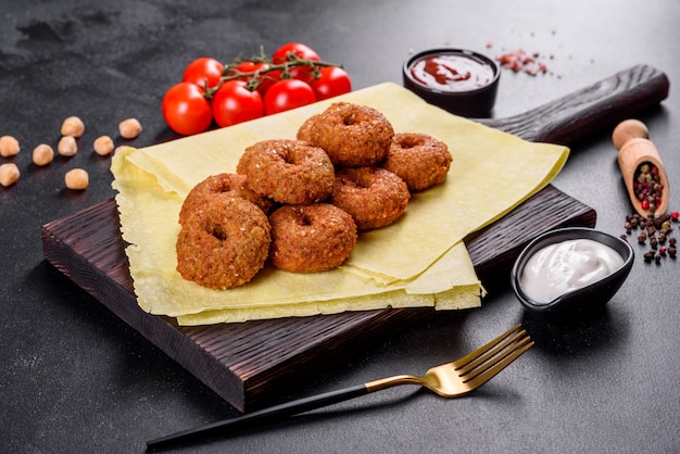 Beautiful delicious fresh chickpea falafel with sauces on a concrete background. Elements of Vegitarian Cuisine