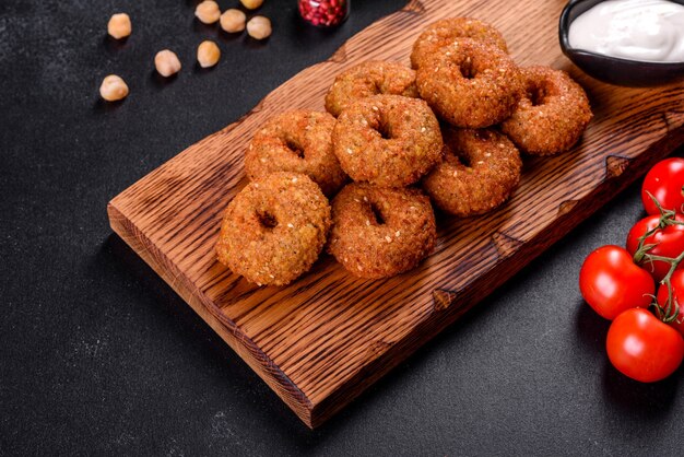 구체적인 배경에 소스와 함께 아름 다운 맛있는 신선한 병아리 콩 팔라 펠. 채식 요리의 요소