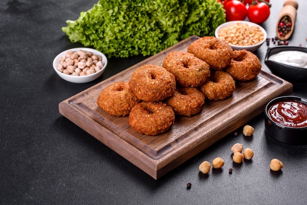 Beautiful delicious fresh chickpea falafel with sauces on a concrete background. Elements of Vegitarian Cuisine