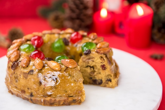 Beautiful delicious homemade  Christmas fruit cake on white platter 