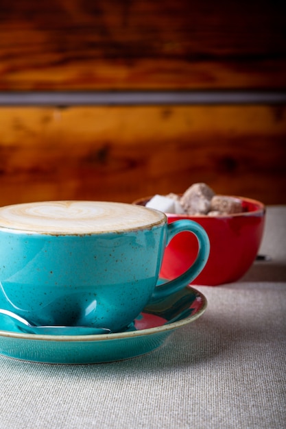 Beautiful Delicious Latte art, Blue coffee cup with Brown sugar on wooden background.