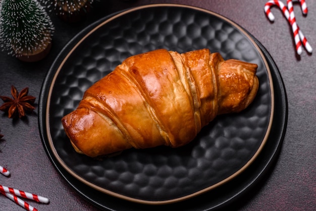 Beautiful different Christmas decorations and croissant on a brown concrete table