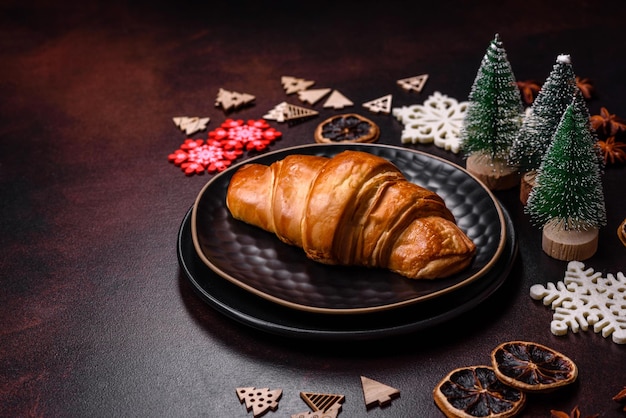 Beautiful different Christmas decorations and croissant on a brown concrete table