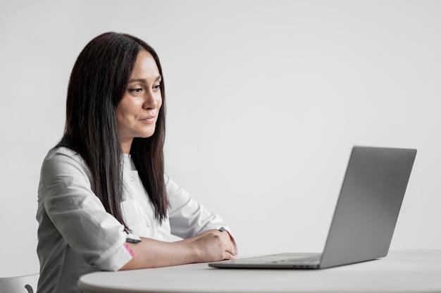 Beautiful doctor browsing laptop