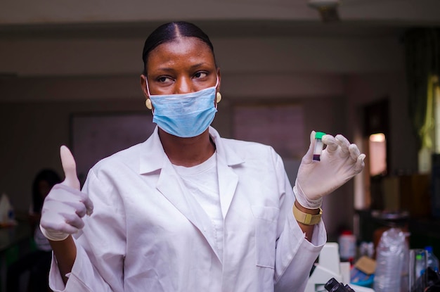 Beautiful doctor hold a blood sample on her hand and did thumbs up