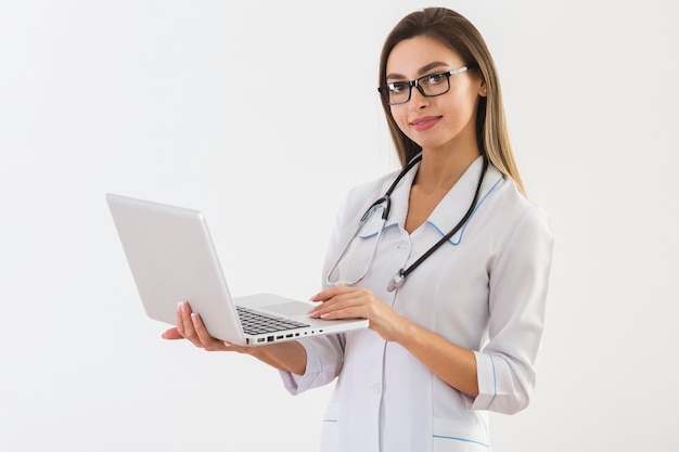 Foto bello medico che tiene un computer portatile e che esamina fotografo