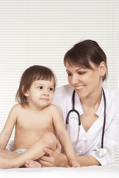 Beautiful doctor with little girl in her office