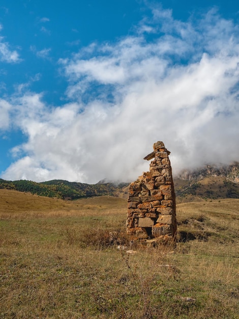 Beautiful dramatic landscape nature view in the mountains Old Ossetian battle tower in the misty mountains Digoria region North Ossetia Russia Vertical view