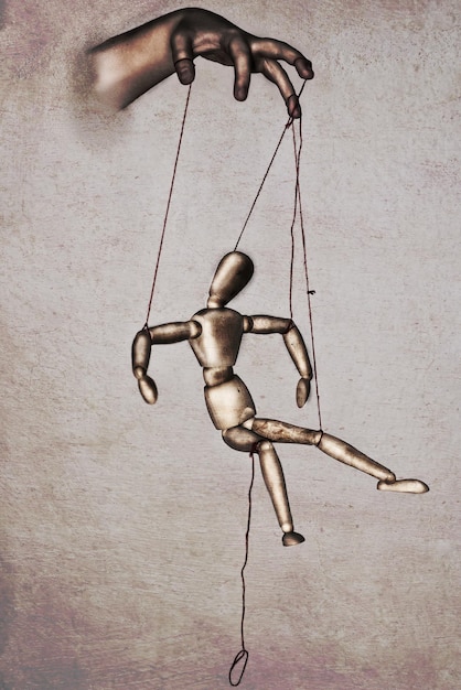 Photo beautiful drawing of a marionette manipulated by a puppeteer - concept of pliability