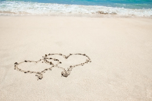 Beautiful drawing on the sand near the sea shore background