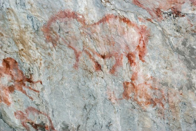 Beautiful drawings of ancient people in red ocher on the walls of a limestone cave