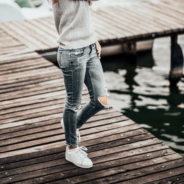 Beautiful dreaming woman walking on pier by the lake.