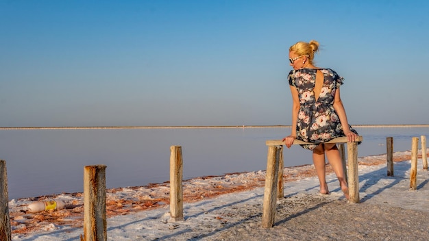 In a beautiful dress with gentle lips on the background of a white lake of salt blue clouds