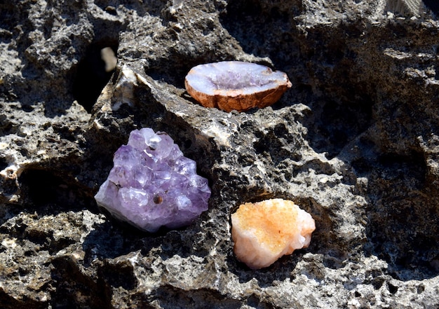 A beautiful druse and geode of amethyst and druse of citrine lie on a stone Crystals of semiprecious stones in the sun