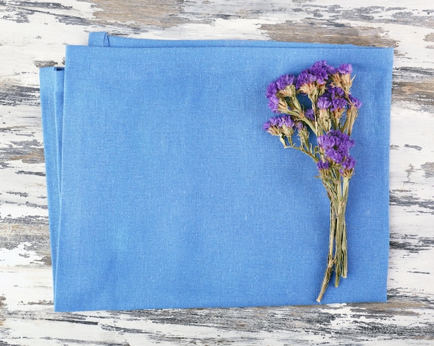 Beautiful dry flowers on napkin on wooden background