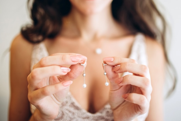 Beautiful earrings on the palm of the bride