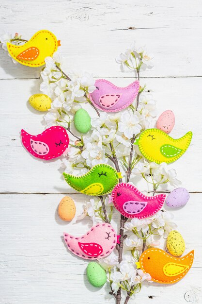 Beautiful Easter background with traditional decor Flowers decorative eggs birds and rabbits Modern hard light dark shadow white boards flat lay top view