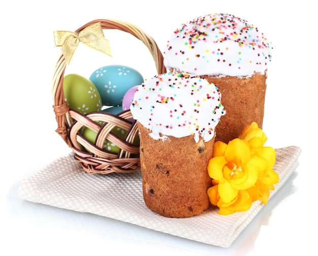 Beautiful Easter cakes colorful eggs in basket and flowers isolated on white