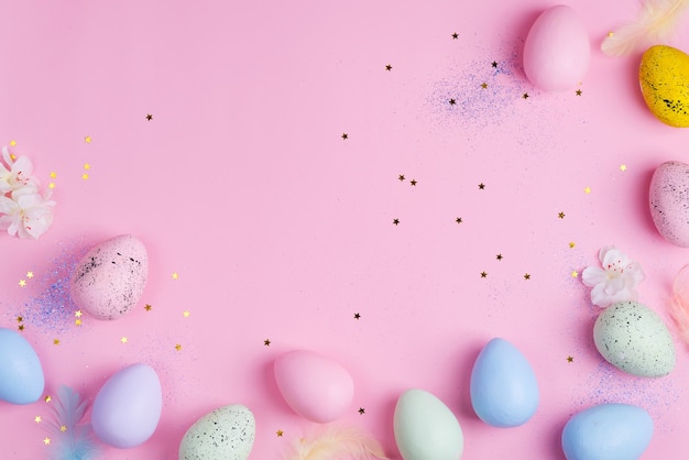 Beautiful Easter color pastel eggs on pink stars background with copy space