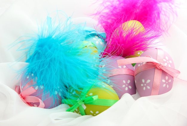 Beautiful easter eggs and decorative feathers close up