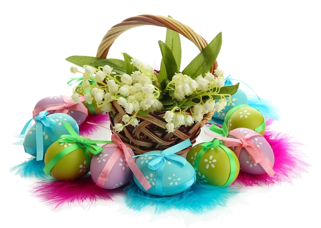 Beautiful easter eggs and lilies of the valley in basket isolated on white