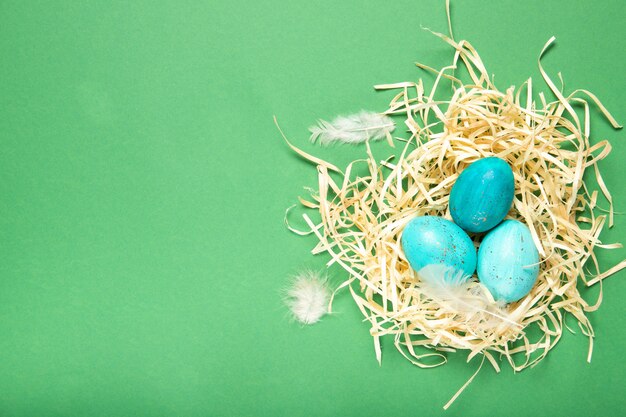 Photo beautiful easter eggs in a nest on a green background