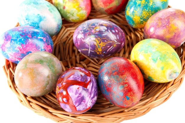 Beautiful Easter eggs in wicker basket closeup