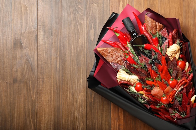 Beautiful edible bouquet with meat cheese and vegetables on wooden table top view Space for text