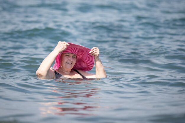 A beautiful elderly woman bathes in the sea