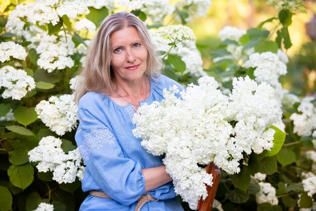 Beautiful elderly woman with a bouquet of flowers Smiling woman in her garden