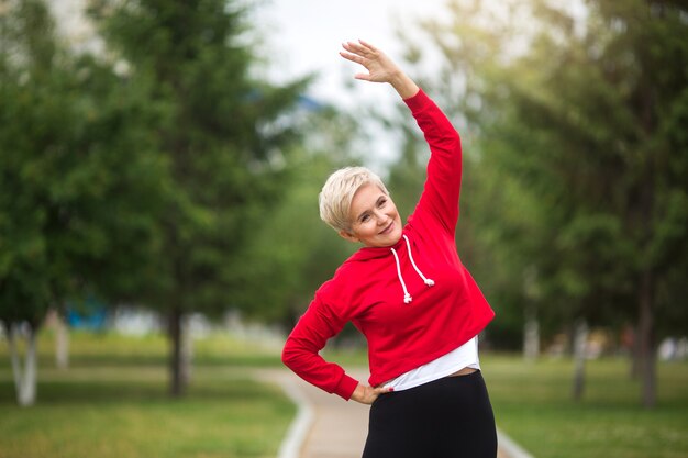 Photo beautiful elderly woman with short haircut goes in for sports in the park