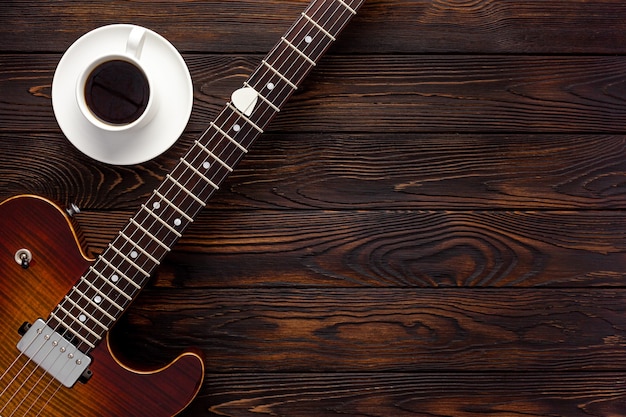 Beautiful electric guitar on with headphones and coffee\
desktop