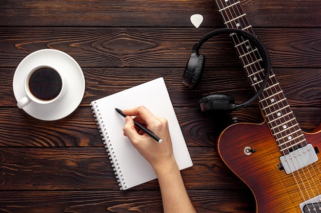 Photo beautiful electric guitar on with headphones and coffee desktop