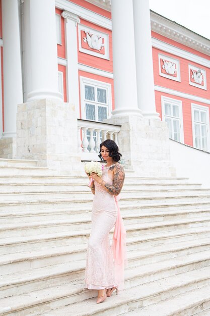 Beautiful elegant brunette woman in pink dress