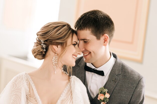 Beautiful elegant couple of newlyweds in love in a luxurious interior near the piano