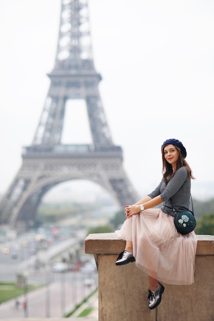 Beautiful elegant girl in Paris a beauty in a blue beret on the background of the Eiffel Tower