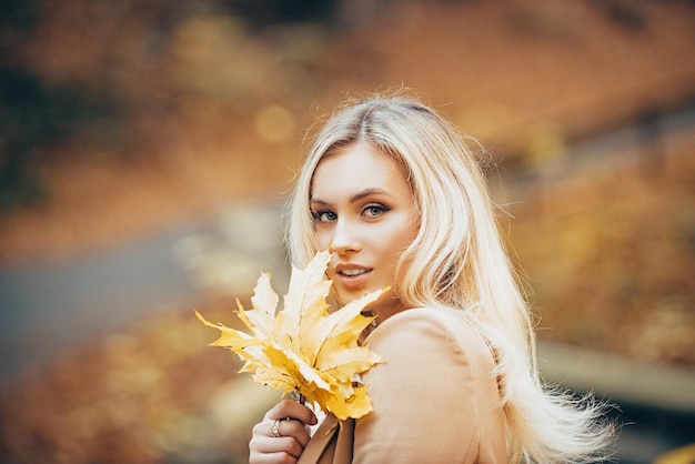 Beautiful elegant woman in autumn leaf park.