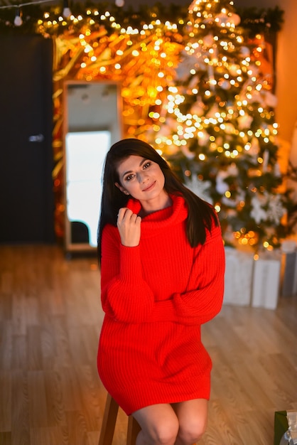 Beautiful elegant woman near the Christmas tree