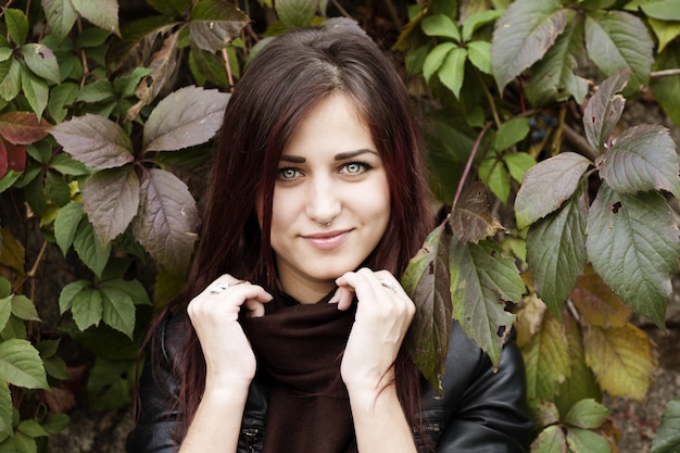 Beautiful elegant woman standing in a park in autumn