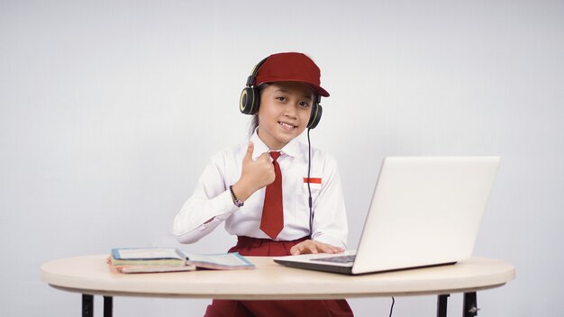 Beautiful elementary school girl studying properly isolated on a white background