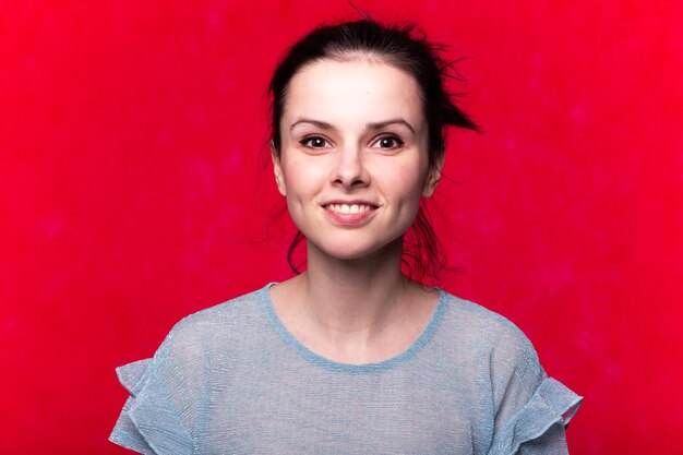 beautiful emotional girl in a blue tshirt on a red background