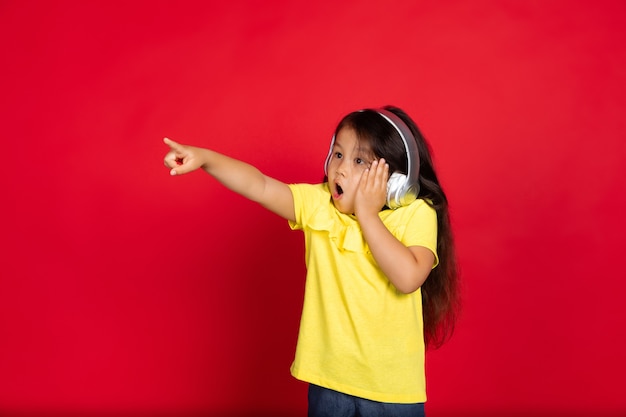 Beautiful emotional little girl isolated on red halflenght portrait of happy child