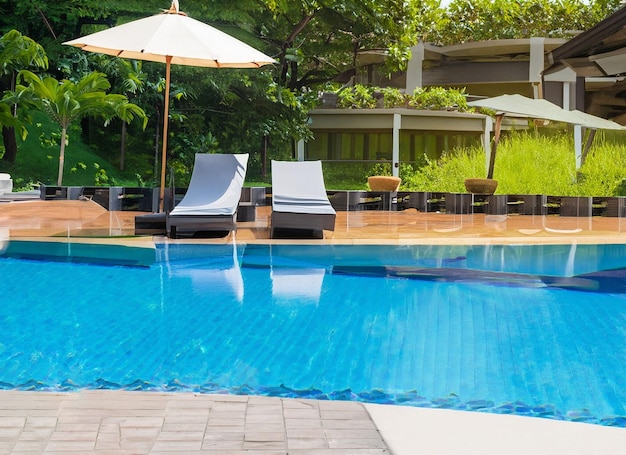Beautiful empty chair with umbrella around outdoor swimming pool in hotel resort for vacation travel