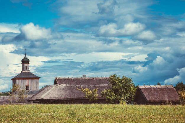 Beautiful ethnic houses on rural landscape Retro styled