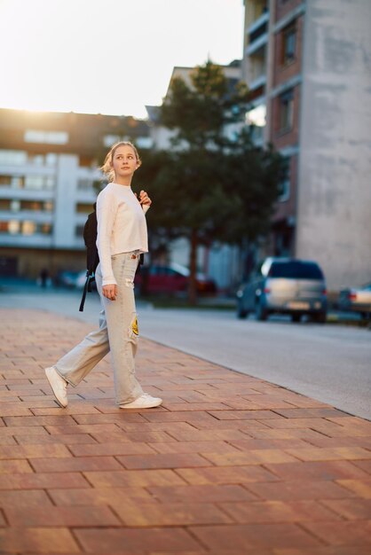 Photo a beautiful european teenager captured in a sideprofile portrait walks home during sunset after