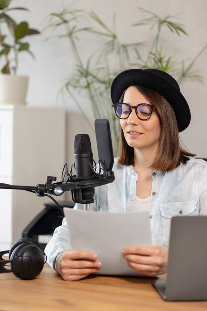 Beautiful european woman podcaster with headphones and microphone records podcast in recording