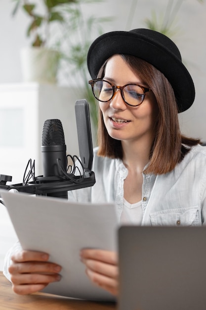 Beautiful european woman podcaster with headphones and microphone records podcast in recording