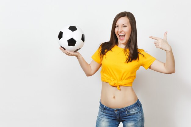 Beautiful european young strong slim sexy woman, football fan\
or player in yellow uniform holding soccer ball isolated on white\
background. sport, play football, health, healthy lifestyle\
concept.