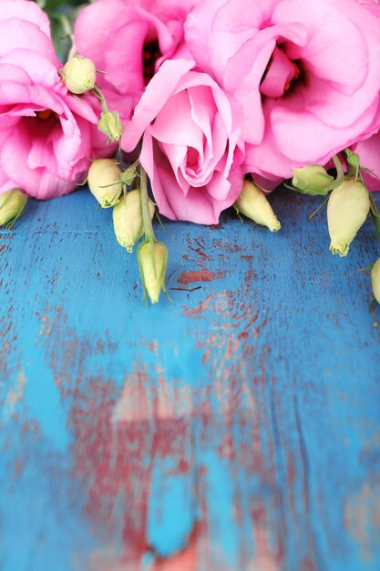 Bellissimi fiori di eustoma su fondo di legno