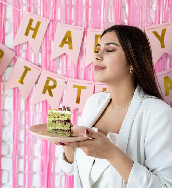 Photo beautiful excited woman celebrating birthday holding cake making wish